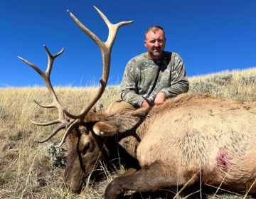 A bull elk hunter posing after the hunt